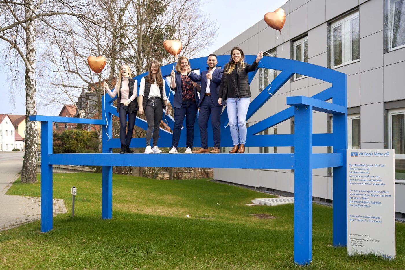 Teammitglieder auf der blauen Bank vor der Filiale in Heilbad Heiligenstadt 